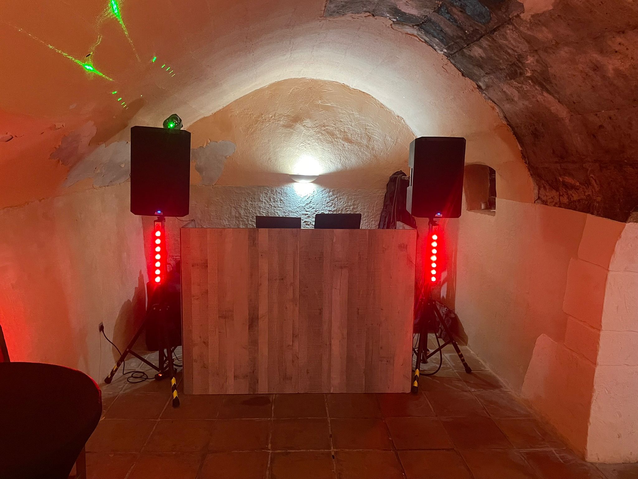 Cabina DJ de madera con altavoces e iluminación roja